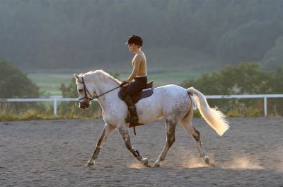 lady riding grey horse 